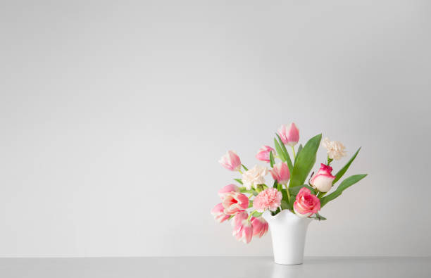 istock pink spring flowers in white ceramic vase in modern home interior 1926781174