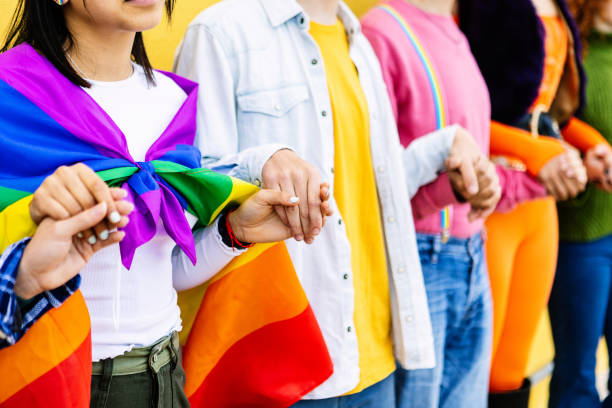istock Young group of LGBT people holding hands outdoors showing support and unity. 1926792302