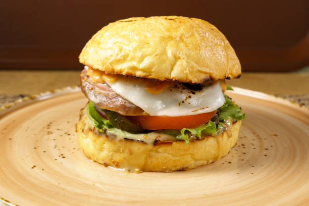istock Burger with beef tongue, cheese salad and tomato close-up. Selective focus 1926798073