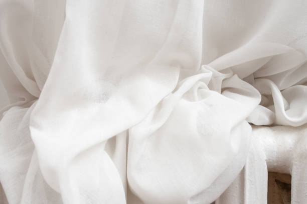 istock White drapes resting on a metal heater, abstract texture backdrop 1926807596