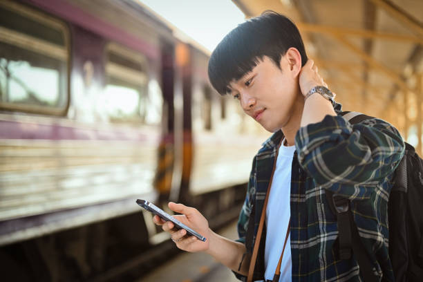 istock Handsome male traveler checking timetable train schedule for trip with application on smartphone 1926833509