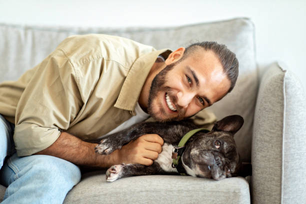 istock Happy young man with his dog at home 1926849062