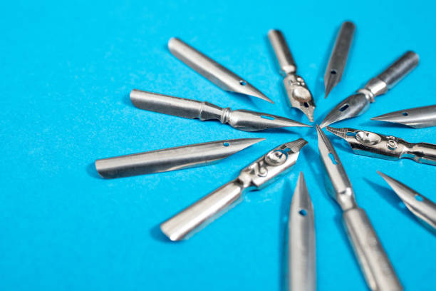 Multiple vintage pen nibs pointing to the same direction, teamwork concept, soft focus