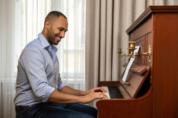 istock Man practicing playing piano in living room of his home relaxing from work 1926860183