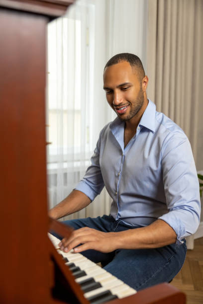istock Man sitting at piano  and playing at home 1926860185