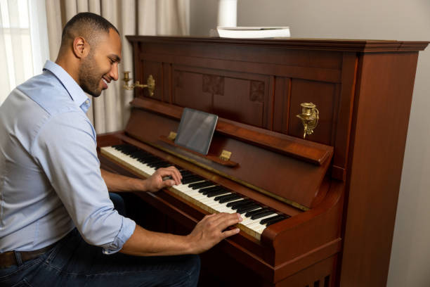 istock Man practicing playing piano in living room of his home relaxing from work 1926860693