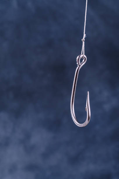 Large fishing hook on gray and blue background with space for text