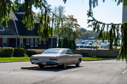 Gananoque on Lake Ontario, a port for The Thousand Islands boat tours.  A classic American car, 1966 Pontiac Catalina, in a car park near the tour boat pier.