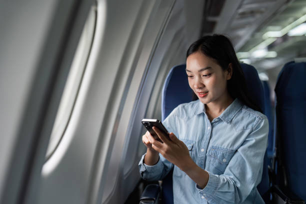 istock Asian people female person onboard, airplane window, using mobile while on the plane 1926880538