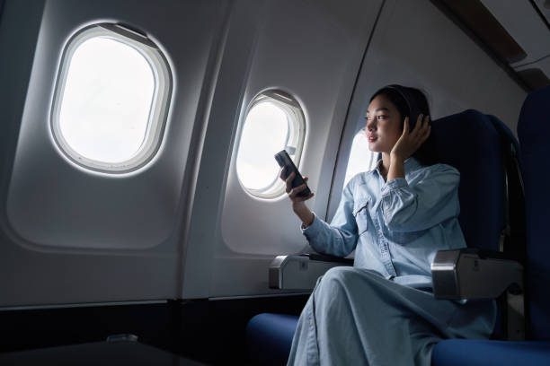 istock Asian people female person onboard, airplane window, using mobile while on the plane 1926881045
