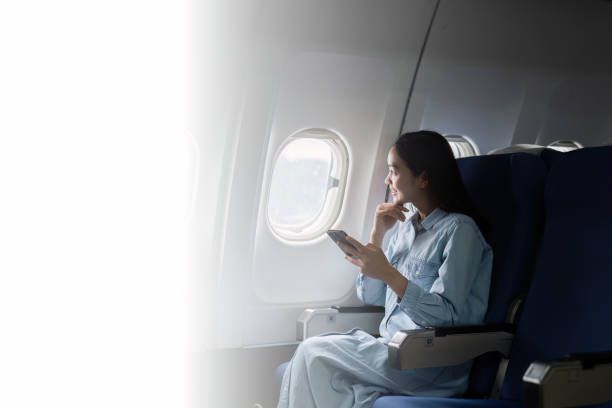 istock Asian people female person onboard, airplane window, using mobile while on the plane 1926881058
