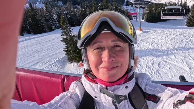 Adult woman smiling joyfully while going uphill to ski, Austria