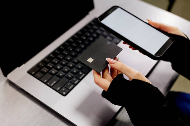 istock Top view, female hands holding smartphone white screen mockup to display your graphic advertisement and credit card on computer keyboard background. Online payments, mobile banking, online shopping. 1926905642