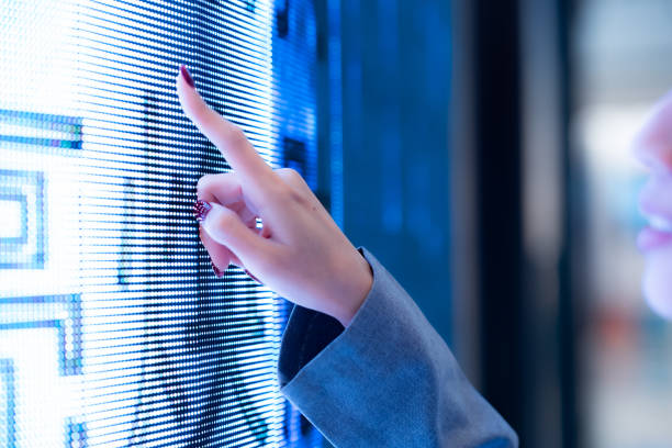 istock Focus woman hand pointing at blue digital screen with blur face background. 1926910465
