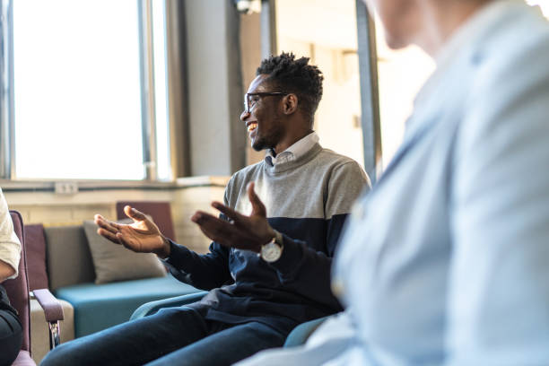 istock An adult man, looking happy, talking with random people from the group therapy 1926942315