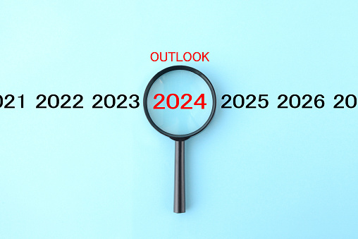 Magnifying glass and annual number 2024 with OUTLOOK word