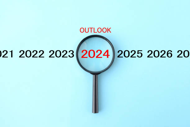 magnifying glass and annual number 2024 with outlook word - scrutiny analyzing finance data zdjęcia i obrazy z banku zdjęć