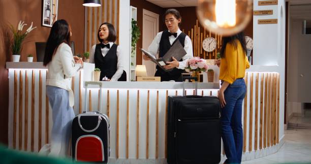 istock Hotel employees greeting customers at front desk in lobby 1926953339