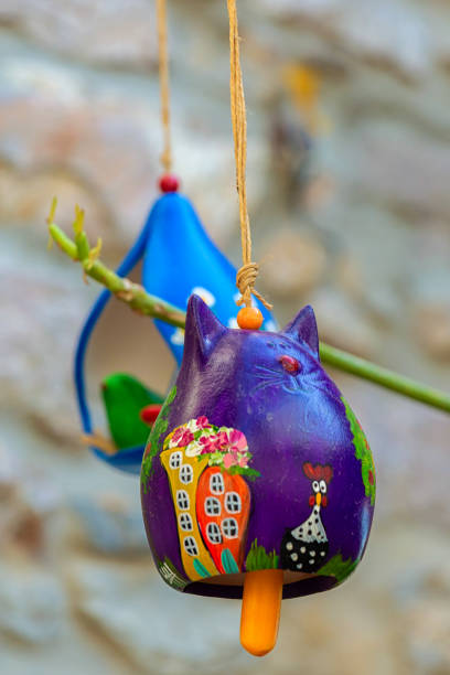 Two multicolored ceramic cats on pendant, in form of bells. Creative house decoration or souvenir. Vibrant colors. October 15, 2023. Bodrum (Mugla), Turkey (Turkiye)