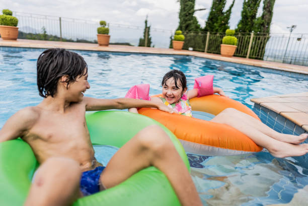 istock Siblings in the swimming pool at a hotel 1926980314
