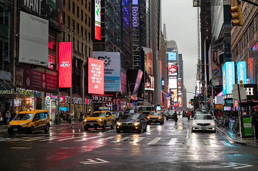New York, USA - October 29, 2023: Traffic on intersection of 7th Avenue and 41nd Street in Manhattan, rainy day in New York.