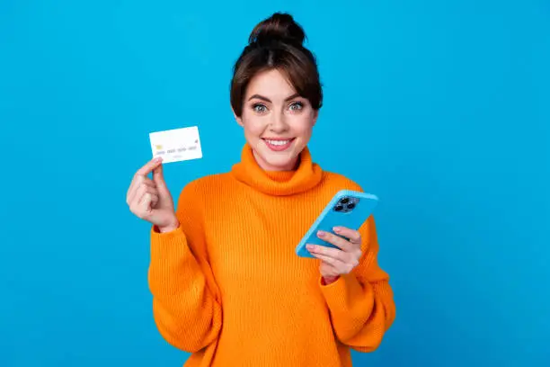 Photo of good mood cheerful lady wear knitted pullover online shopping modern device isolated blue color background.