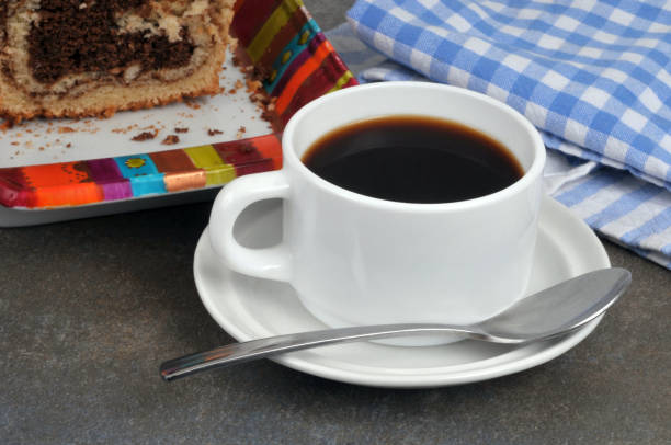 Cup of coffee with a spoon and a marble cake