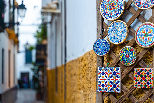 Ceramic tiles hanging on a door in the old neighborhood of Santa Cruz Santa Cruz neighborhood also known as the Juderia or Jewish quarter of Seville in Andalucia, Spain.