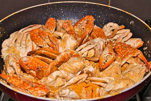 Festive dinner, garlic butter crabs in cooking pan.