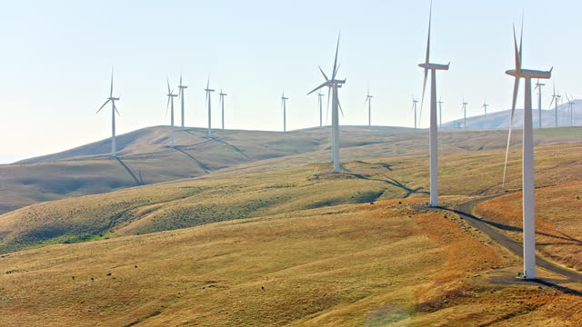 AERIAL Windmill blades turning on the windmill farm on the hills in Washington, USA