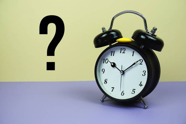 istock Question mark and alarm clock on yellow and purple background 1927050224