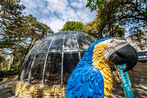 Bournemouth, UK. 22 May 2023. A wooden parrot by the Public aviary in Bournemouth gardens, open to all in the public park