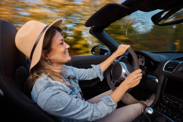 istock Happy woman enjoying while going on a trip in convertible car. 1927090216