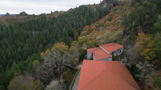 Beautiful aerial drone shot of an old monastery san pedro de rocas construction surrounded by large trees, nature and mountains.