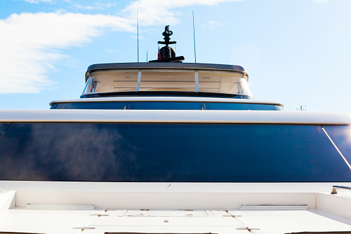 Frontal view of a luxury motor yacht, against a clear sky.