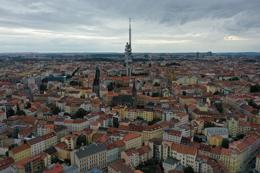 The Zizkov Television Tower stands tall in this drone photograph, dominating the skyline of Prague. Its futuristic design punctuates the city's rooftops and contrasts between modernity and traditional