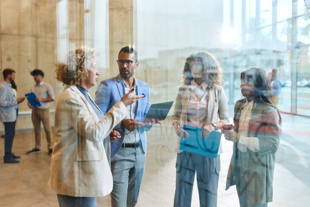 istock Team of business colleagues talking while working in a hallway. 1927126581