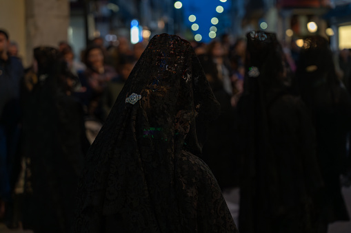 Procession through the streets of Valladolid-Spain, some women parade dressed in rigorous black, they are dressed in mourning with a headscarf known in the Hispanic culture as 
