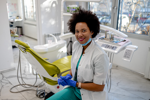In her small business office, an African American dentist demonstrates her commitment to patient health and dental hygiene, captured in a professional portrait