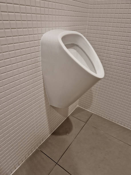 istock urinal lined with white ceramic tiles square texture mosaic. wall-mounted flush toilet and concealed flush with two dosing buttons for more and less water 1927179228
