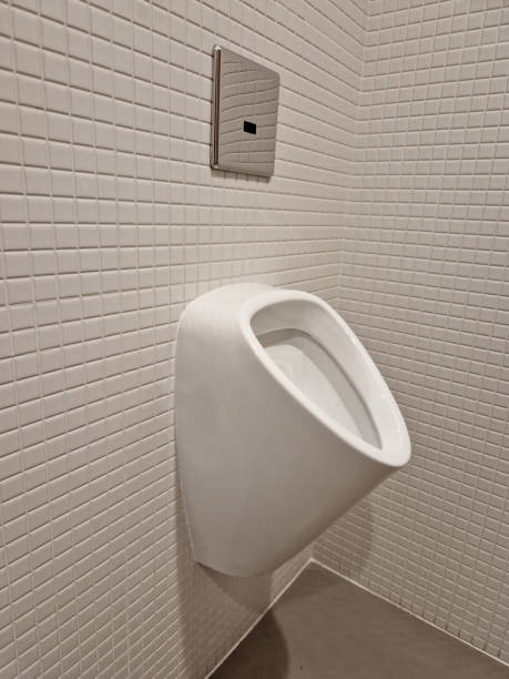istock urinal lined with white ceramic tiles square texture mosaic. wall-mounted flush toilet and concealed flush with two dosing buttons for more and less water 1927179229