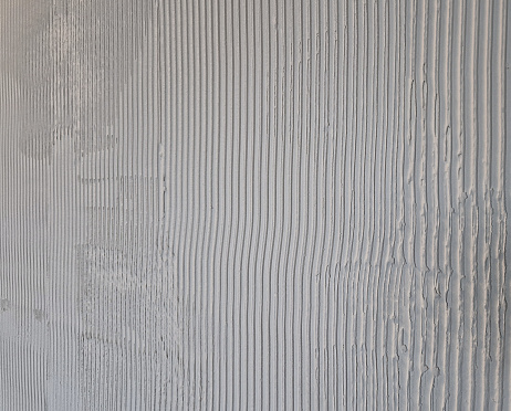 cement screed on wall. squeegee with striped ribbing. the striped plaster surface in the interior is made of plaster. intention of industrial appearance. sockets for switches that are not plug, billiard, plasterboard, screed