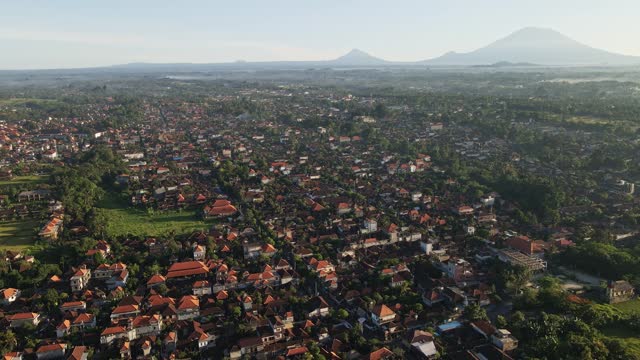 Establishing shot of cultural town called Ubud with the view at volcano Agung at the background during sunrise in Bali, Indonesia