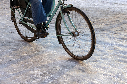 Woman rides a bike on an icy bike path