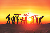 Group of happy skiers and snowboarders silhouettes at sunset