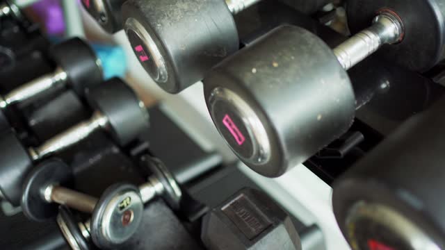 Dumbbells and weights sitting on a rack in a health club