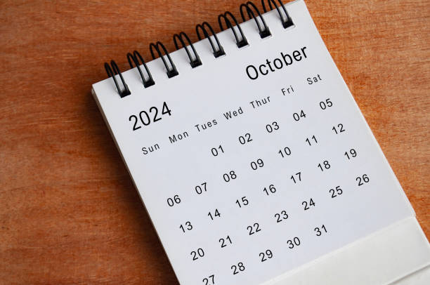 istock October 2024 white table calendar on wooden background. Calendar concept. 1927237904