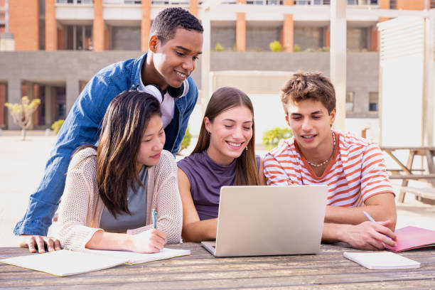 istock A group of students with laptops sit near the campus and communicate. 1927251747