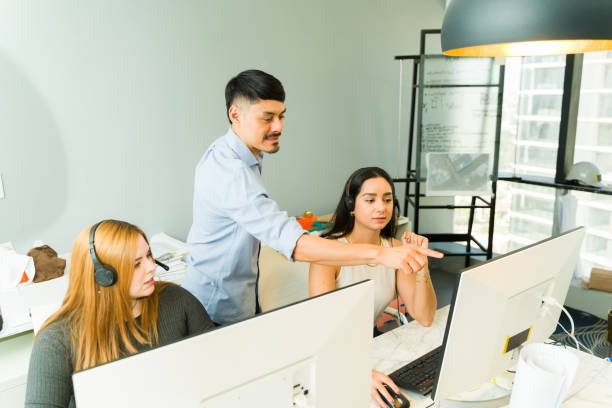 istock Latin mentor helping a customer support agent with one of her calls 1927252863