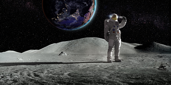 An astronaut in full space suit, standing alone on the lunar surface holding up a smart phone and taking a selfie with the planet earth in the background. Earth image from NASA: https://eoimages.gsfc.nasa.gov/images/imagerecords/90000/90008/asia_vir_2016_lrg.png